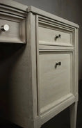 Load image into Gallery viewer, Close-up of beige wooden executive desk drawer and cabinet with silver knob handles in neutral setting