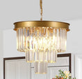 Load image into Gallery viewer, Gold crystal chandelier with three-tier elongated crystal bars and matte gold metal frame hanging in a room