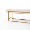 Load image into Gallery viewer, Beige upholstered bench with rounded edges and brass-finished steel frame on a white background
