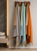 Load image into Gallery viewer, Reversible mulberry silk throw blankets in gray, beige, blue, and orange hanging on a wooden wall rack.