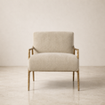 Load image into Gallery viewer, A modern accent chair with a textured cream-beige upholstered seat and backrest, featuring a natural wood frame and legs, set against a minimalist beige wall and concrete floor.