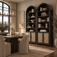 Load image into Gallery viewer, A pair of tall black bookcases with beige cabinet doors and gold handles, styled with books, bowls, and greenery in a warm, modern dining room.