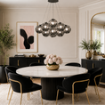 Load image into Gallery viewer, Black globe chandelier with smoked gray glass shades hanging above a round marble dining table
