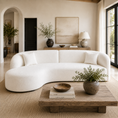 Load image into Gallery viewer, Boucle curved sofa in a beautifully styled, warm-toned living room with a rustic wooden coffee table, potted plants, and neutral decor.