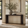 Load image into Gallery viewer, A dark brown console table styled with a large textured gray vase containing green branches, a small dark bowl, and a white sculptural object on books, set against a warm beige wall with a framed abstract print.