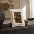 Load image into Gallery viewer, decorative frame with a wide inner mat holding a vintage-style photograph, displayed on a dark tabletop in a styled interior setting with books, a bowl, and dried branches.
