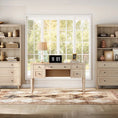 Load image into Gallery viewer, desk with it's parts broken out and the are against the wall and the center piece is on an area rug in front of window facing the window