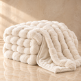 Load image into Gallery viewer, A chunky, oversized chenille throw blanket in a warm cream or off-white color, styled on a polished marble floor against a textured beige wall.