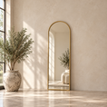 Load image into Gallery viewer, Gold arched mirror with slim frame leaning against a warm neutral wall