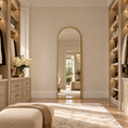 Load image into Gallery viewer, Gold arched mirror styled as a full-length floor mirror in a walk-in closet