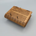 Load image into Gallery viewer, Folded wooden travel cribbage board with brass and black pegs on smooth gray surface background