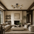 Load image into Gallery viewer, A modern multi-light sputnik chandelier with six spherical glass shades hangs in a styled living room with beige sectional sofas, a low concrete coffee table, and dark wood ceiling beams.