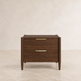 Load image into Gallery viewer, A mid-century modern two-drawer nightstand in dark brown wood with slim brass handles, set against a neutral beige background.