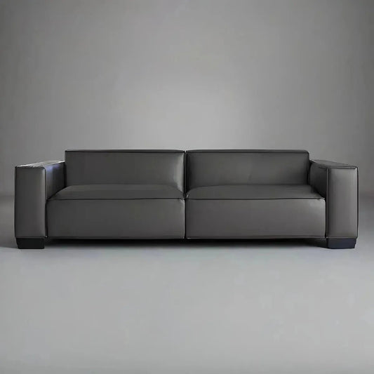 A luxurious, dark gray leather sofa with a low backrest and wide armrests, the BLACK MODERN SOFA from House of Effy stands out against a plain, light gray background.