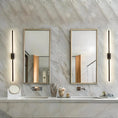 Load image into Gallery viewer, A modern bathroom with a marble countertop, two sinks, and two mirrors flanked by sleek and elegant House of Effy MODERN LINEAR SCONCE. Various bathroom essentials are arranged on the countertop, enhancing the contemporary design.
