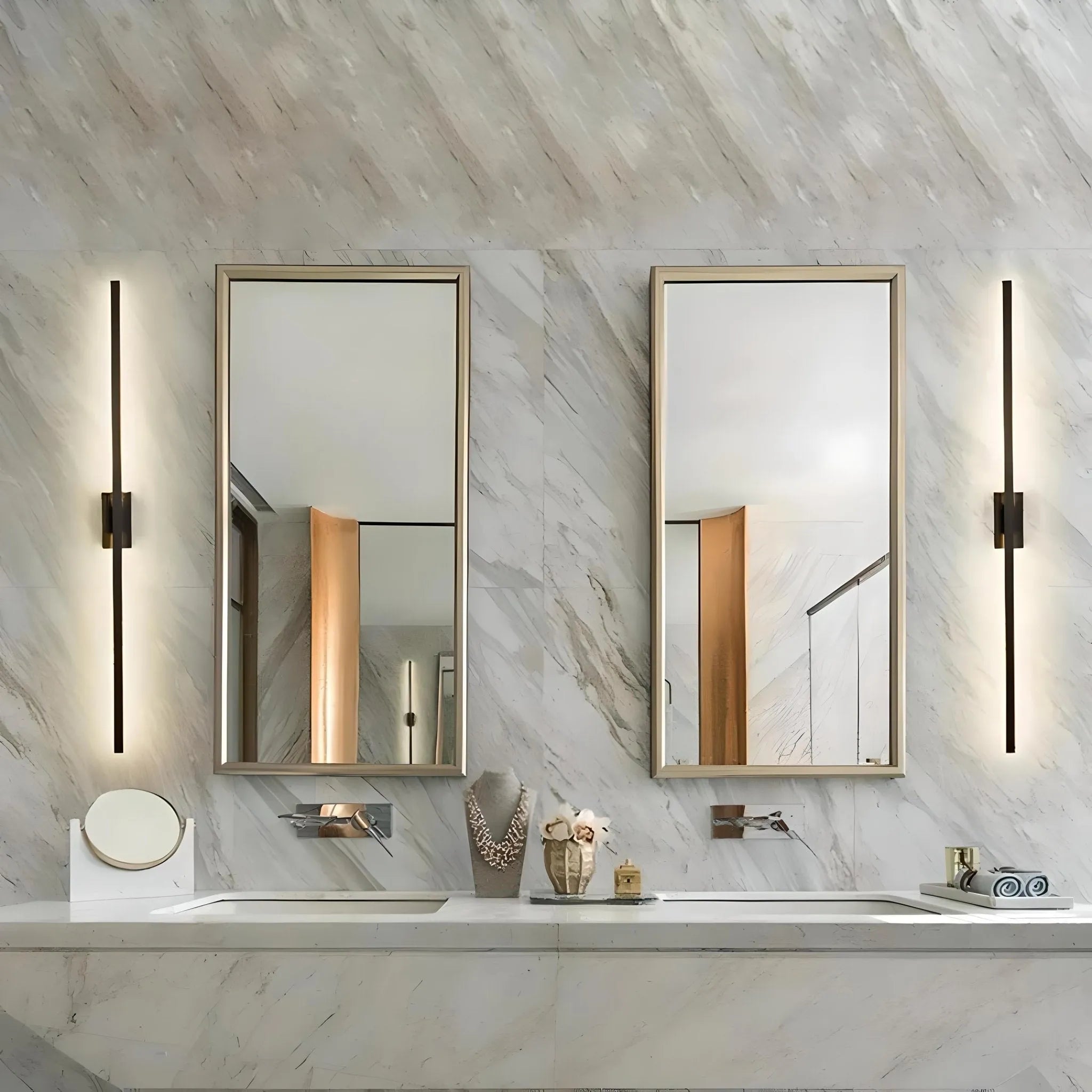 A modern bathroom with a marble countertop, two sinks, and two mirrors flanked by sleek and elegant House of Effy MODERN LINEAR SCONCE. Various bathroom essentials are arranged on the countertop, enhancing the contemporary design.