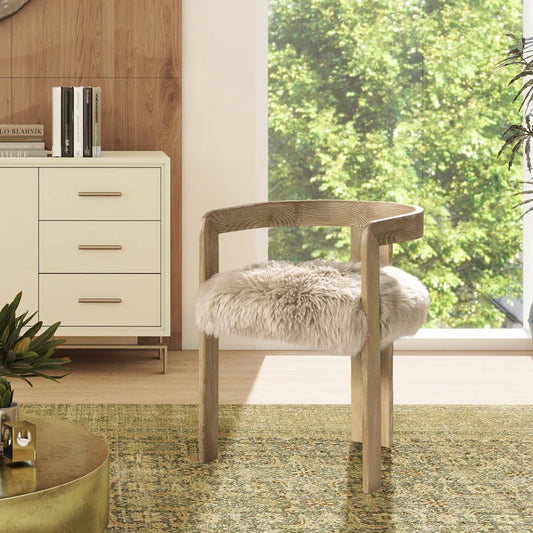 sheepskin chair angled on an area rug and across from coffee table