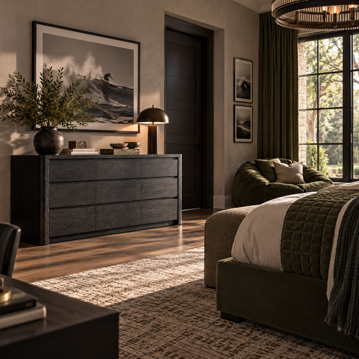 A styled bedroom interior featuring a dark wood dresser with a framed landscape print, a table lamp, and a potted plant, alongside a bed with green bedding and a large window with dark green curtains.
