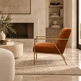 Load image into Gallery viewer, A modern accent chair with a rust-orange velvet seat and a gold metal frame, styled in a warm, contemporary living room setting.
