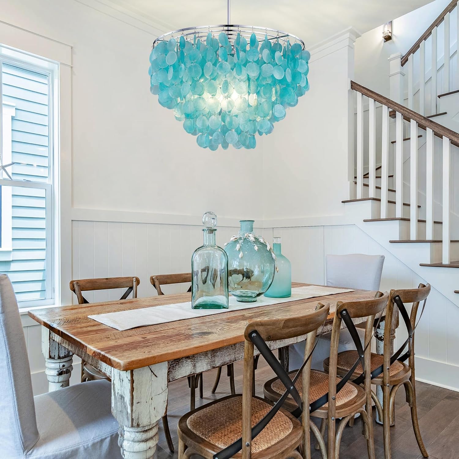 Capiz Shell Chandelier is in a dining room over a dining room table