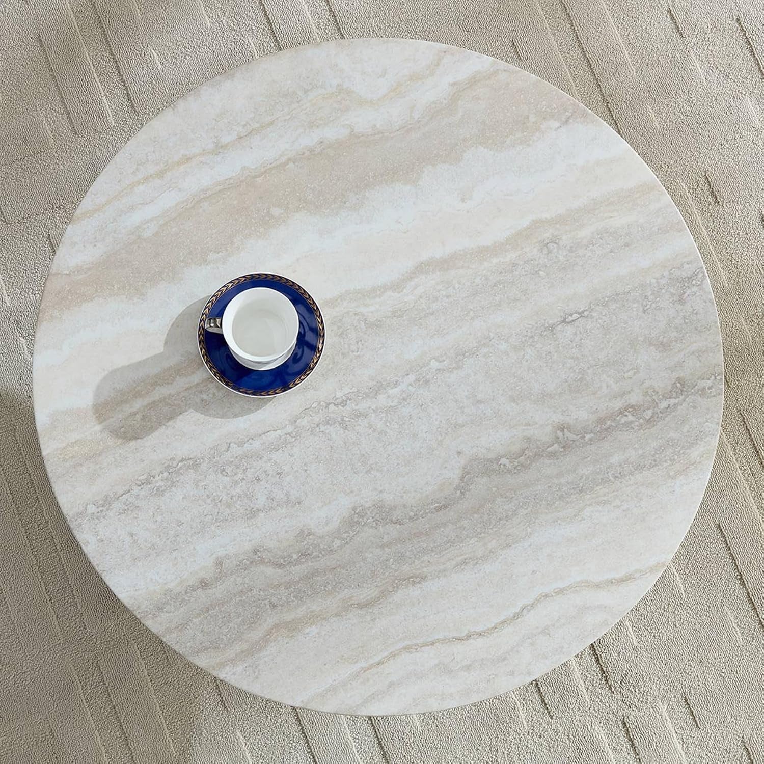 Cora Coffee Table is sitting on a rug and this view is looking down on it and it has  tea cup sitting on top of it