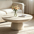 Load image into Gallery viewer, Cora Coffee Table in a living room with flowers on it and it is placed on an area rug across from a sofa
