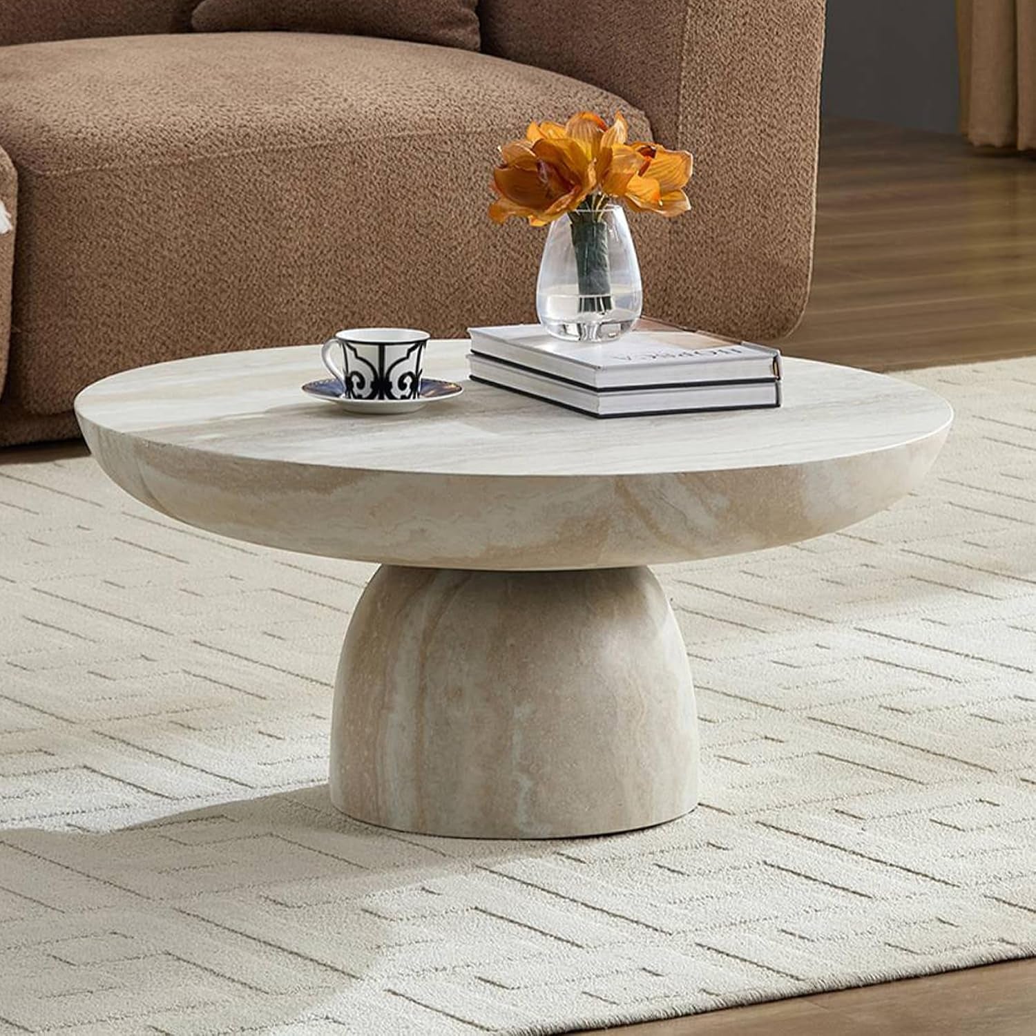Cora Coffee Table has a vase with flowers on it and some books