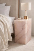 Load image into Gallery viewer, Emma Pink Onyx Table beside bed in bedroom with lamp and glass cup on it
