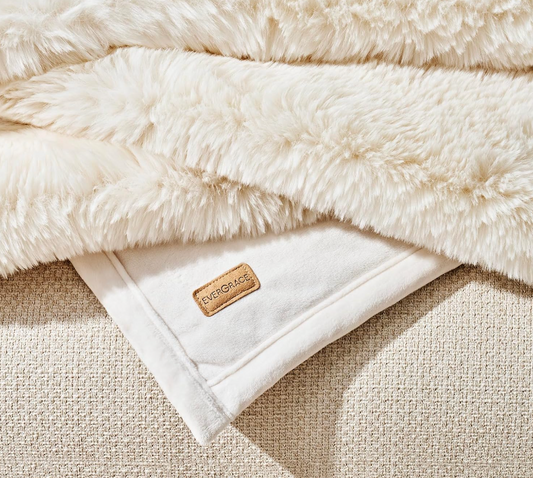 Faux Chinchilla Throw White close-up folded over itself showing the tag with logo on it