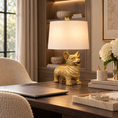 Load image into Gallery viewer, Gold Corgi Lamp with white drum shade on a dark wood office desk beside a laptop and white hydrangeas.
