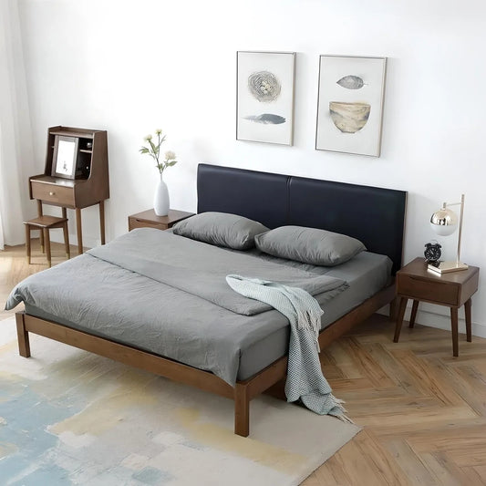 Bedroom with a neatly made House of Effy BROWN WOOD BED, gray bedding, and a black headboard flanked by two nightstands holding lamps. Wall art and a small desk with a chair are positioned against the white walls, creating a sophisticated bedroom featuring luxurious wood accents.