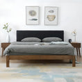 Load image into Gallery viewer, Bedroom with a luxurious House of Effy BROWN WOOD BED bed frame and dark grey bedding. Two nightstands with lamps flank the bed. Above the headboard are two abstract artwork pieces. A white and pastel rug is on the floor, enhancing the sophisticated atmosphere.
