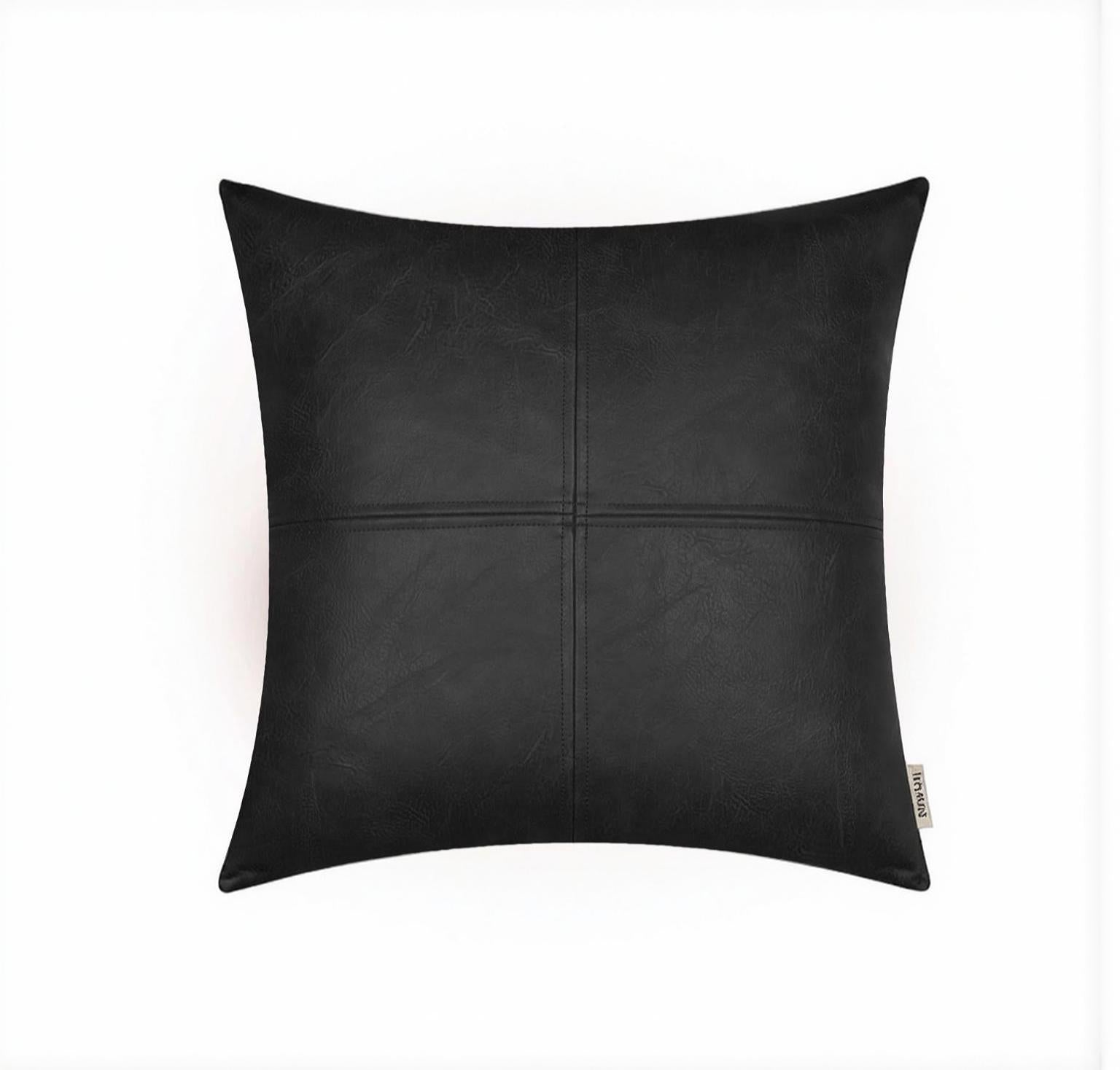 Square black faux leather pillow cover with stitched patchwork design on white background