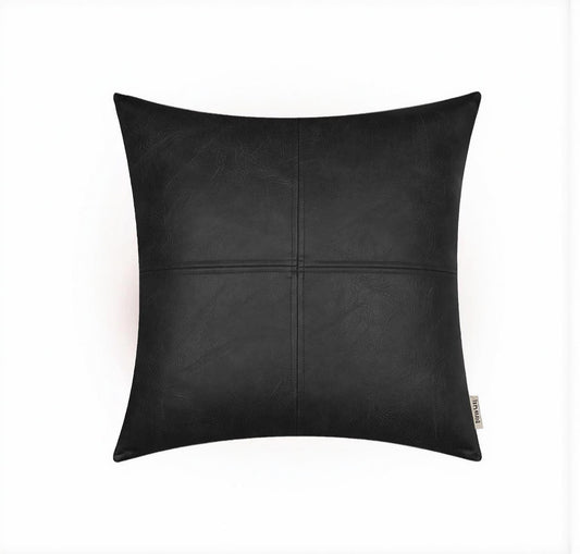Square black faux leather pillow cover with stitched patchwork design on white background