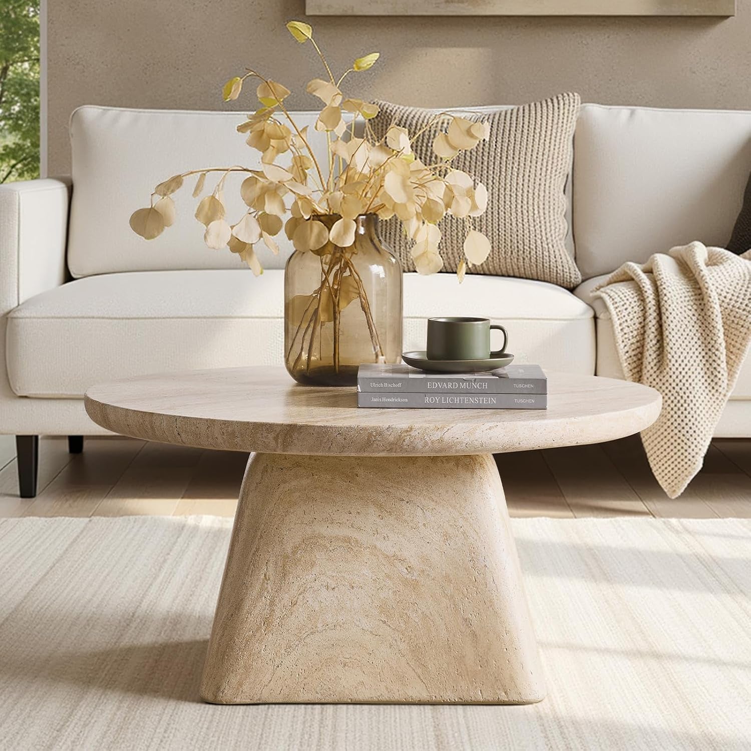 LUCAS COFFEE TABLE IN LIVING ROOM SIDE VIEW WITH VASE AND BOOKS ON IT AND A SOFA IN THE BACKGROUND