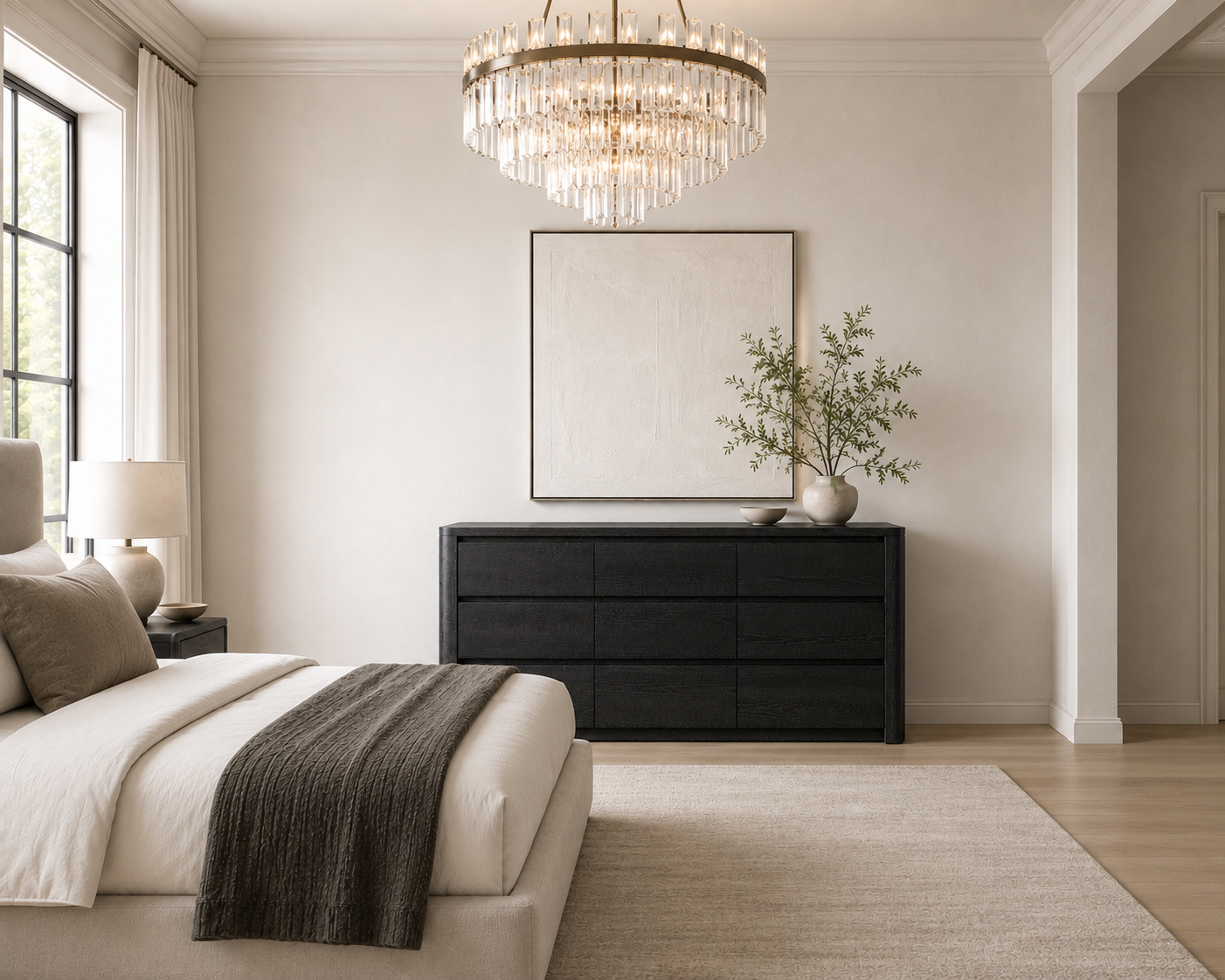 Maura Dresser in a room with a chandelier, bed, and end table with lamp