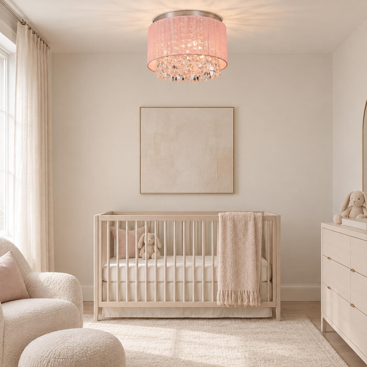 A modern nursery room featuring a light wood crib with a cream knit blanket, a pink crystal drum chandelier, and soft beige walls.