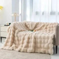 Load image into Gallery viewer, A beige, plush House of Effy TUSCAN THROW is draped over a light-colored sofa next to a white nightstand with a small lamp. The room is well-lit with natural light from a window, evoking winter warmth and cozy comfort.
