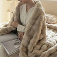 Load image into Gallery viewer, Person wearing a beige cardigan sitting on a bed, draped in a House of Effy TUSCAN THROW of plush material and reading a magazine. Bright, neutral-colored room, exuding winter warmth.
