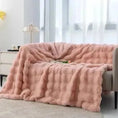 Load image into Gallery viewer, A pink, plush blanket from the House of Effy TUSCAN THROW collection is draped over a gray couch in a bright room with a window, a small side table, and a lamp. Perfect for adding winter warmth to your cozy space.
