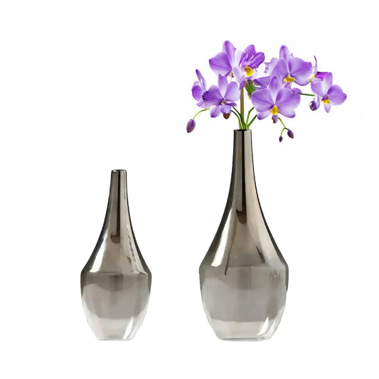 Two glass vases on a white background, one empty and the other holding a bunch of purple orchids: one is a House of Effy Modern Minimalist Vase.