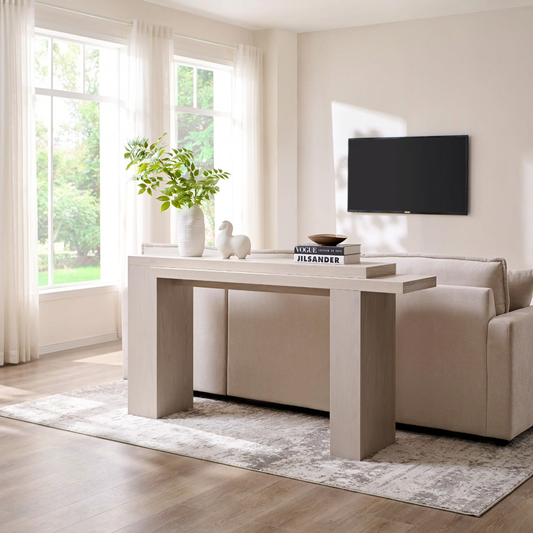WOODEN CONSOLE TABLE IN LIVING ROOM BEHIND A SOFA AND ON TOP OF AN AREA RUG