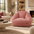 Load image into Gallery viewer, A dusty pink corduroy chair in a beautifully styled living room with a fireplace, beige sofa, and stone coffee table.
