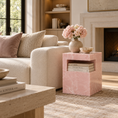 Load image into Gallery viewer, A pink stone table with a built-in shelf, styled in a cozy living room next to a cream sofa with pink pillows.

