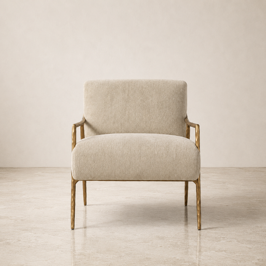A modern accent chair with a textured cream-beige upholstered seat and backrest, featuring a natural wood frame and legs, set against a minimalist beige wall and concrete floor.