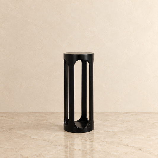 A rectangular wall mirror with a thin black frame and a silver inner trim, mounted on a textured beige plaster wall.