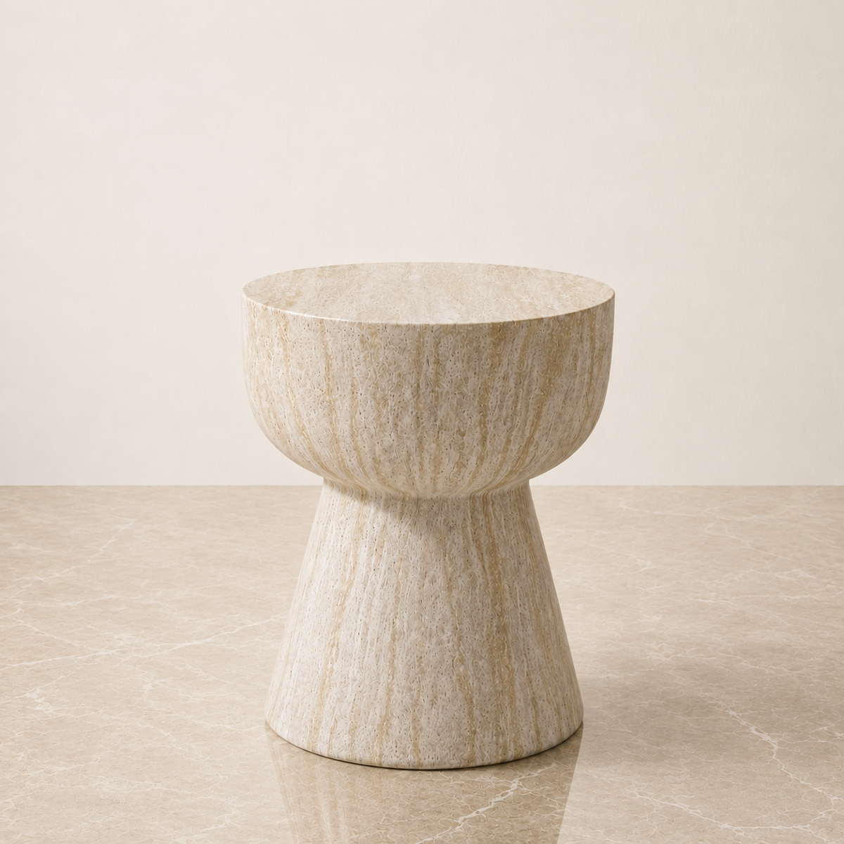 A modern pedestal stool made of textured beige travertine stone, set against a minimalist beige background.