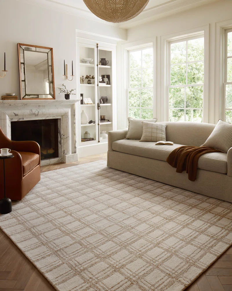 area rug in living room with a sofa and accent chair and a chandelier hanging from ceiling