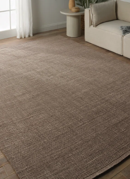 brown area rug in living room with sofa and side table