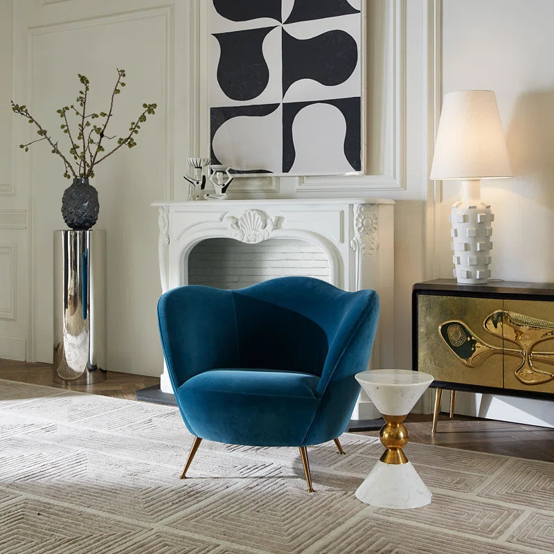 barrel chair in living room in front of fire place and an end table with a lamp on it